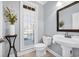 Stylish half bath with pedestal sink, framed mirror, and shuttered window, accented with a decorative flower arrangement at 212 Minnow Ln., Murrells Inlet, SC 29576