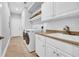 Functional laundry room with white cabinetry, tile flooring, granite counters, and modern appliances at 212 Minnow Ln., Murrells Inlet, SC 29576