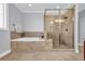 Elegant bathroom featuring a soaking tub, a tiled glass shower, and neutral tiling throughout at 212 Minnow Ln., Murrells Inlet, SC 29576