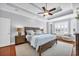 Serene main bedroom with tray ceiling, ceiling fan, bay window, and wood furnishings on hardwood flooring at 212 Minnow Ln., Murrells Inlet, SC 29576