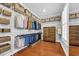 Organized walk-in closet with built-in shelving, hanging rods, wooden floors, and natural light from a window at 212 Minnow Ln., Murrells Inlet, SC 29576