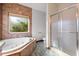 Bathroom with a jacuzzi tub, glass shower, and a window overlooking the green trees at 2531 Smiley Ln., Conway, SC 29526