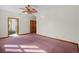 Bedroom with pink carpet, a ceiling fan, closet doors, and an open doorway to the bathroom at 2531 Smiley Ln., Conway, SC 29526