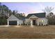 Stunning farmhouse exterior boasts a gray and white color scheme, two-car garage, and welcoming front porch at 270 Russ Rd., Loris, SC 29569