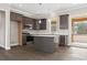 Modern kitchen with dark wood cabinets, a large island with quartz countertop, and access to a backyard patio at 270 Russ Rd., Loris, SC 29569