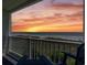 Balcony view of beach and water; features a picturesque sunset against the horizon and vegetation at 3701 S Ocean Blvd. S # 206, North Myrtle Beach, SC 29582