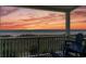 Balcony view of beach and water with chairs; features a picturesque sunset against the horizon and vegetation at 3701 S Ocean Blvd. S # 206, North Myrtle Beach, SC 29582