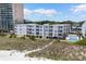 Exterior view of the condo complex from the beach, with path, green space, and pool view at 3701 S Ocean Blvd. S # 206, North Myrtle Beach, SC 29582