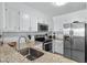 Well-lit kitchen featuring stainless steel appliances, granite countertops, white cabinets, and a stylish backsplash at 3701 S Ocean Blvd. S # 206, North Myrtle Beach, SC 29582