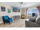 Bright living room with comfortable seating, ceiling fan, and sliding doors leading to a balcony with ocean views at 3701 S Ocean Blvd. S # 206, North Myrtle Beach, SC 29582