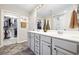 Bathroom featuring double sinks, a large mirror, decorative vases, and a walk-in closet at 3713 Park Pointe Ave., Little River, SC 29566