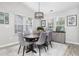 Bright dining room with a large round table, six chairs, modern chandelier, and lots of natural light at 3713 Park Pointe Ave., Little River, SC 29566