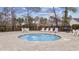 Community's splash pool surrounded by paving stones featuring lounge chairs, tables, and a grill at 3713 Park Pointe Ave., Little River, SC 29566