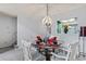 Cozy dining room with a glass table, white chairs, and decorative chandelier at 4396 Baldwin Ave. # 94, Little River, SC 29566