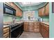 Kitchen featuring wood cabinets, tile countertops, and black appliances at 4396 Baldwin Ave. # 94, Little River, SC 29566