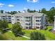 Exterior angle showcases architecture, lush greenery and walkway to parking at 4851 Luster Leaf Circle # 302, Myrtle Beach, SC 29577