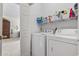 Laundry room features a washer, dryer, and shelving for storage with a view into a bedroom at 4851 Luster Leaf Circle # 302, Myrtle Beach, SC 29577