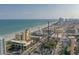 An aerial view captures the beach coastline, with the cityscape, ferris wheel, ocean, and many beach goers at 4933 Crab Pond Ct. # 202, Myrtle Beach, SC 29579