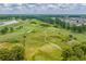 An aerial view of a manicured golf course with lush green fairways, scenic sand traps and surrounding trees at 4933 Crab Pond Ct. # 202, Myrtle Beach, SC 29579