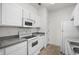 Functional kitchen featuring white appliances and cabinets with granite countertops, ideal for meal preparation at 4933 Crab Pond Ct. # 202, Myrtle Beach, SC 29579