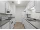 Well-lit kitchen featuring white cabinets, granite countertops, and modern appliances for convenient cooking at 4933 Crab Pond Ct. # 202, Myrtle Beach, SC 29579