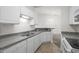 Efficient kitchen with bright white cabinetry, granite counters and modern appliances adjacent to the dining area at 4933 Crab Pond Ct. # 202, Myrtle Beach, SC 29579