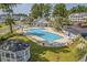 A bright community pool area featuring lounge chairs, umbrellas, and manicured landscaping at 4933 Crab Pond Ct. # 202, Myrtle Beach, SC 29579