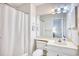 Clean bathroom features a shower with curtain, a toilet, and a vanity with ample lighting at 5001 Little River Rd. # W-214, Myrtle Beach, SC 29577