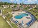 Overhead view of a fenced community pool with lounge chairs, barbecue area, and lush landscaping at 600 Barona Dr., Myrtle Beach, SC 29579