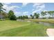 Scenic view of the lush green golf course and pond, surrounded by mature trees under a blue sky at 600 Barona Dr., Myrtle Beach, SC 29579