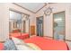 Bedroom with coral bedding, mirrored closet, and view into kitchenette at 6001-6012 S Kings Hwy., Myrtle Beach, SC 29575