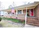 Inviting brick front porch with columns, red door and American flag at 604 Six Lakes Dr., Myrtle Beach, SC 29588