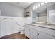 Bright bathroom features double sink vanity, white wainscoting and wood-look flooring at 6644 E Sweetbriar Trail, Myrtle Beach, SC 29588