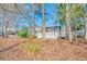 Backyard view of a single-story home with a patio, surrounded by lush greenery and mature trees at 6644 E Sweetbriar Trail, Myrtle Beach, SC 29588