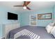 Well-lit bedroom features beach-themed decor, ceiling fan, and television at 719 N Waccamaw Dr., Garden City Beach, SC 29576