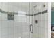 The shower features a glass door and white tiles with a decorative accent stripe at 719 N Waccamaw Dr., Garden City Beach, SC 29576