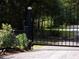 An electric entrance gate leads to a gravel drive and landscaped yard, ensuring privacy at 76 Nailah Ln., Pawleys Island, SC 29585