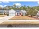 White one-story house with red door, two-car garage, and landscaped yard at 799 Helms Way, Conway, SC 29526