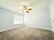 Cozy bedroom has neutral carpet, ceiling fan, window with blinds, and crisp white trim at 8304 Parasol Ct., Myrtle Beach, SC 29579