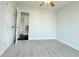 Bright bedroom features neutral carpet, ceiling fan, and white trim with a glimpse into a connecting room at 8304 Parasol Ct., Myrtle Beach, SC 29579