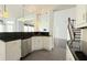 Modern kitchen with black countertops, white cabinets, stainless steel dishwasher, and pendant lighting at 8304 Parasol Ct., Myrtle Beach, SC 29579