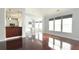 Sunlit living room featuring hardwood floors, large windows and view into modern kitchen and dining nook at 8304 Parasol Ct., Myrtle Beach, SC 29579