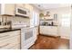 Clean kitchen featuring white appliances, floating shelves, and hardwood floor at 908 Cedarwood Circle, Myrtle Beach, SC 29572