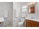 Cozy bathroom with a shower, vanity, and toilet. A small window provides natural light and ventilation at 913 S Dogwood Dr. S, Surfside Beach, SC 29575