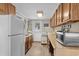 Functional kitchen with wood cabinetry, white appliances, wood flooring, and access to the back entrance at 913 S Dogwood Dr. S, Surfside Beach, SC 29575