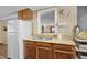 A close-up view of the kitchen sink, wood cabinets, wood countertops, and white appliances at 913 S Dogwood Dr. S, Surfside Beach, SC 29575