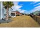 Large backyard featuring a screened in porch, white chairs, green grass, and a privacy fence at 931 Desert Wheatgrass Dr., Myrtle Beach, SC 29579