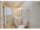 Bright bathroom featuring a sink with vanity, window, toilet, and marble tiled shower at 9450 Old Palmetto Rd., Murrells Inlet, SC 29576