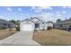 Charming single-story home featuring a well-maintained yard, blue door, and an attached garage at 1130 Ganton Way, Myrtle Beach, SC 29588