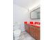 Cozy bathroom featuring subway tile, a bright red countertop, and rich wood cabinetry at 1207 S Ocean Blvd. # 51305, Myrtle Beach, SC 29577